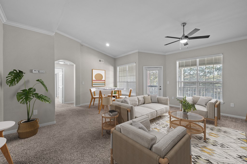 an open living room and dining room with couches and chairs and a ceiling fan