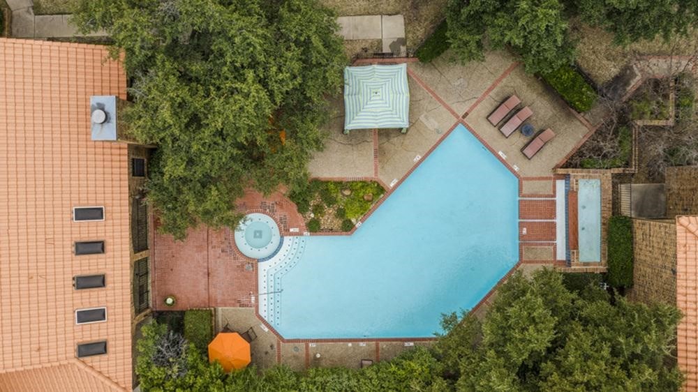 an aerial view of a swimming pool in the backyard of a house