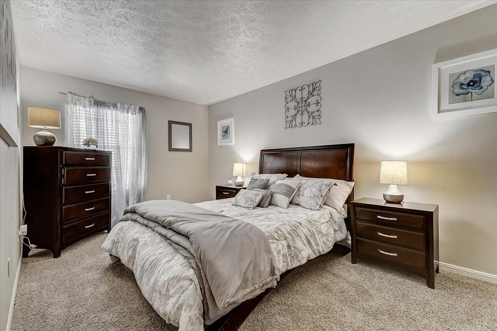 a bedroom with a bed and two dressers