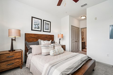 A bedroom with a large bed and two lamps.