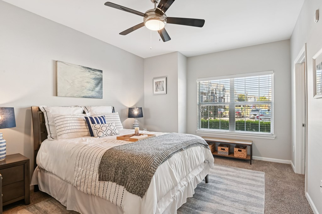 A bedroom with a large bed and a window overlooking a parking lot.