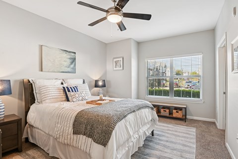 A bedroom with a large bed and a window overlooking a parking lot.