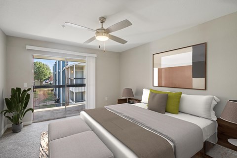 A bedroom with a large bed and a ceiling fan.