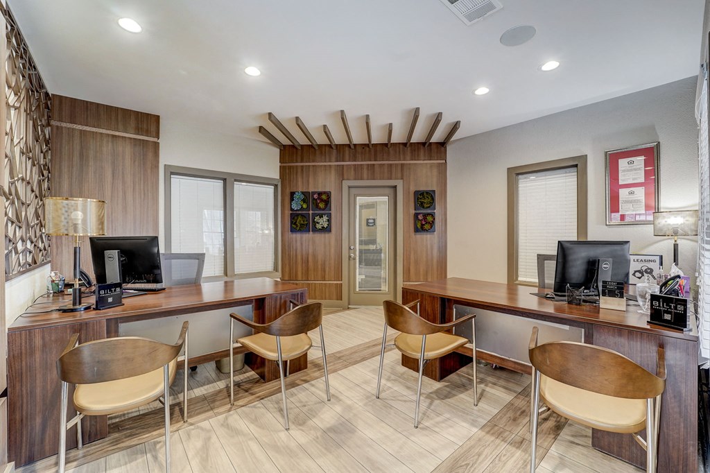 a home office with desks and chairs and a computer