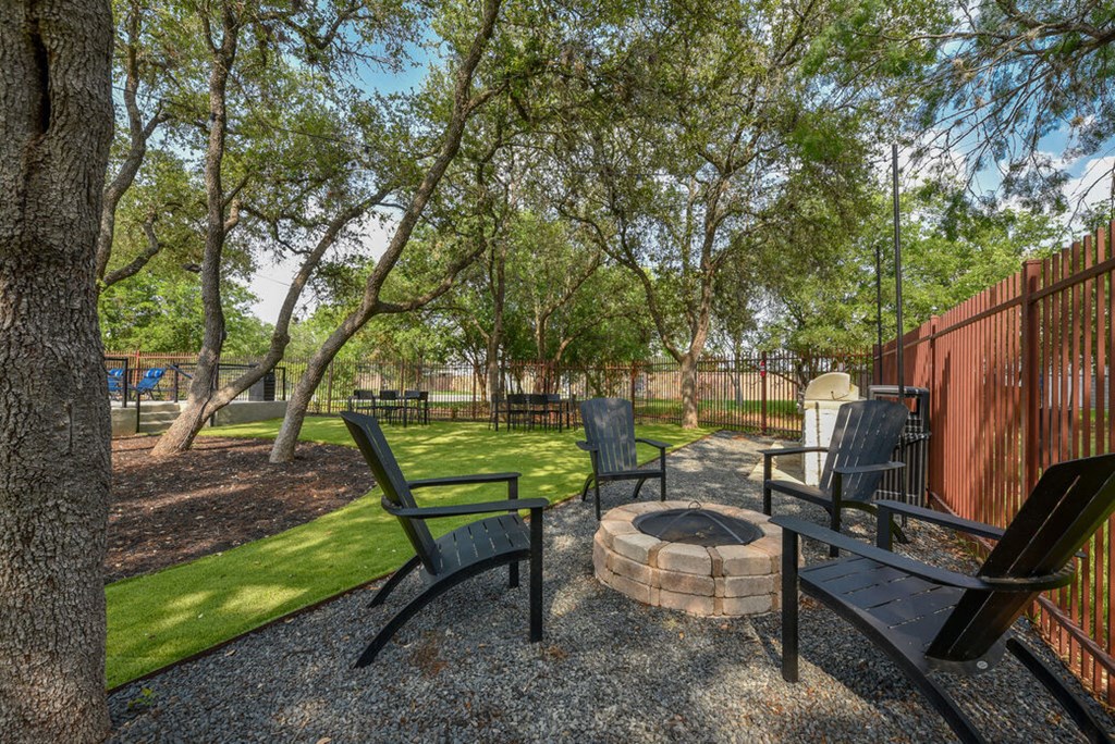 a patio with chairs and a fire pit