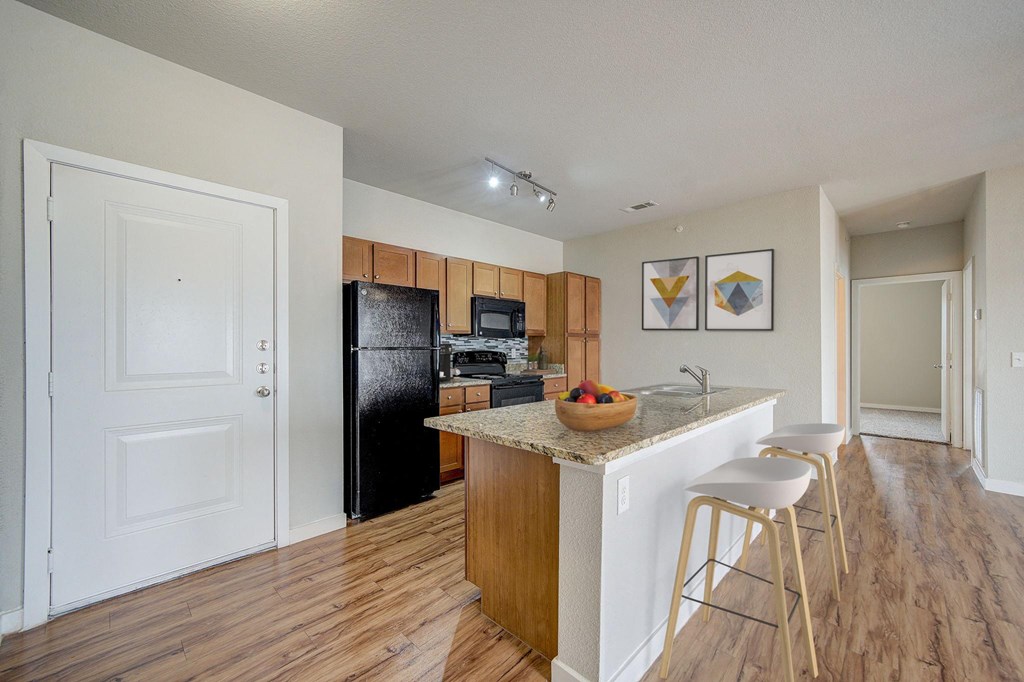 a kitchen with a island and a black refrigerator