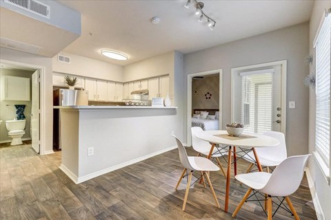 a dining room with a table and chairs next to a kitchen