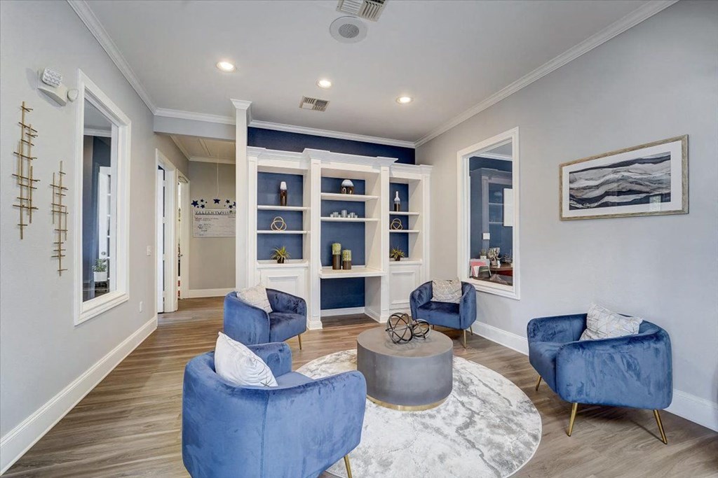 a living room with blue chairs and a rug