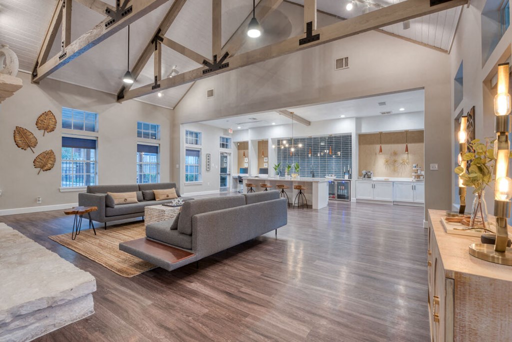 a living room with couches and a kitchen in the background