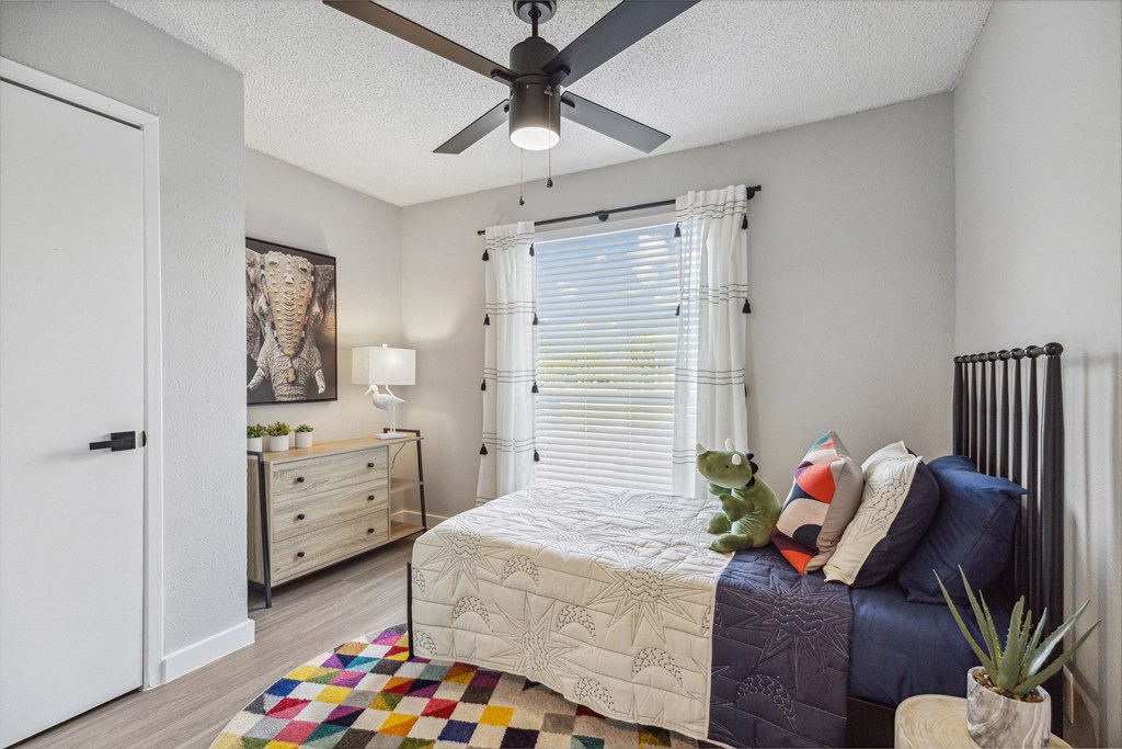 a bedroom with a bed and a ceiling fan