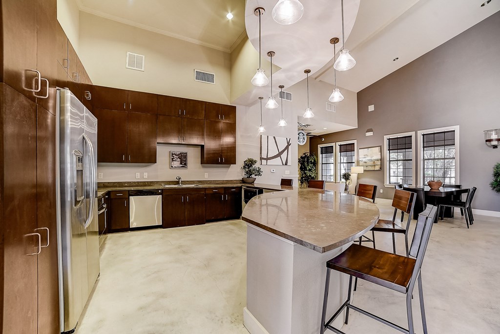 a large kitchen with a large center island with a marble countertop