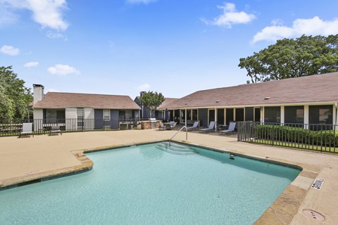 A large swimming pool in a sunny outdoor setting.