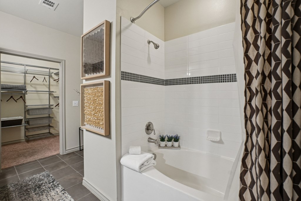 A bathroom with a white tub and a shower.