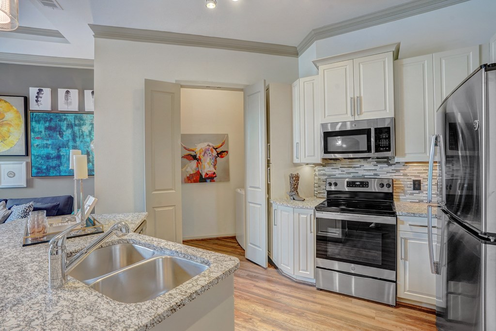 a kitchen with granite counter tops and stainless steel appliances