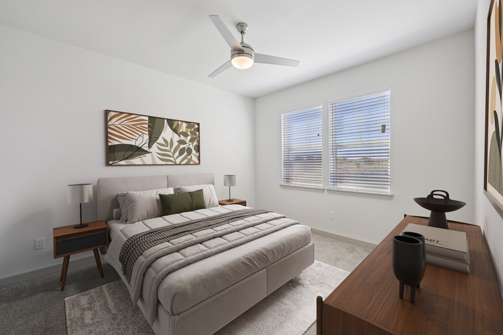 A bedroom with a large bed and a ceiling fan.