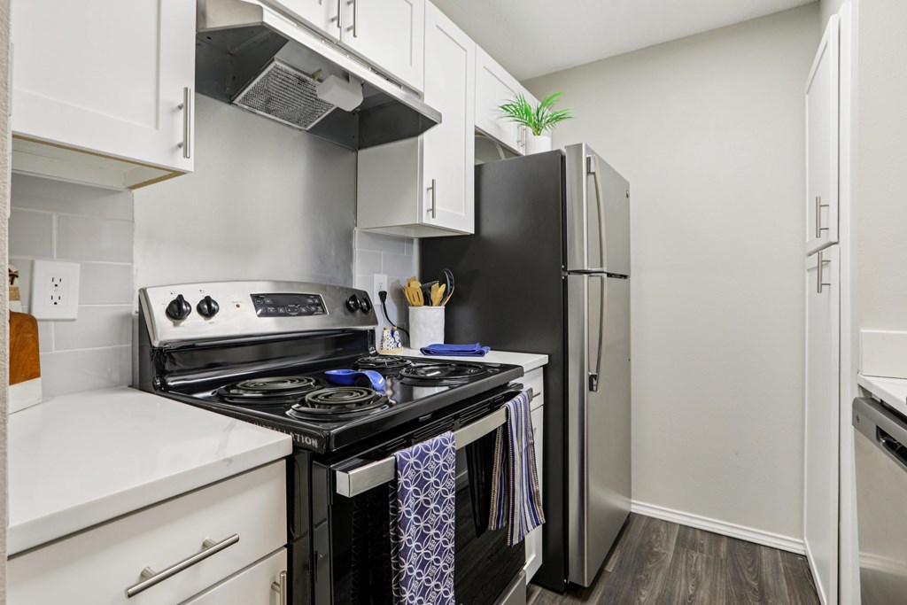 A kitchen with a black stove top oven and white cabinets.