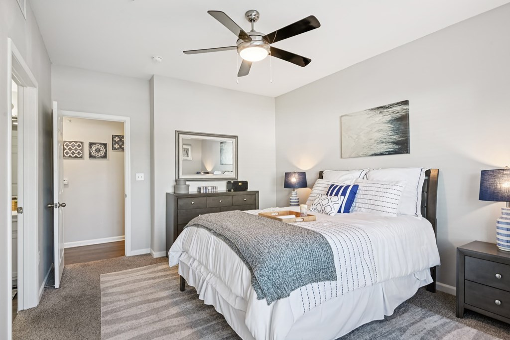 A bedroom with a large bed and a ceiling fan.