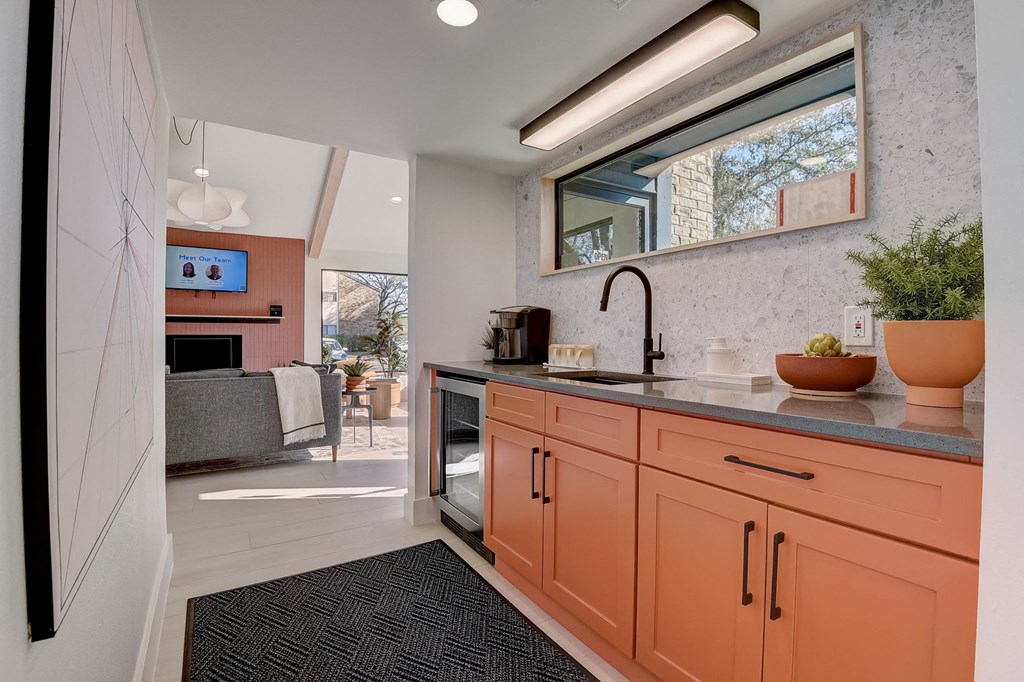 a kitchen with orange cabinets and a sink and a window