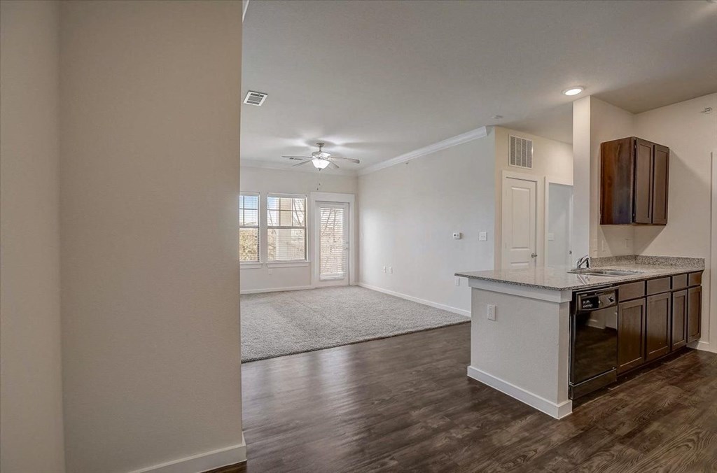 an empty kitchen and living room with a door to the living room