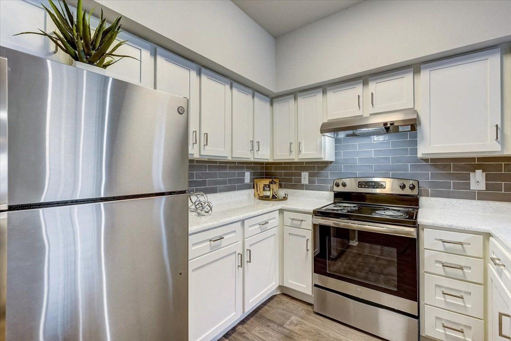a kitchen with stainless steel appliances and white cabinets