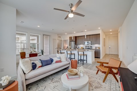 A living room with a white couch and a ceiling fan.