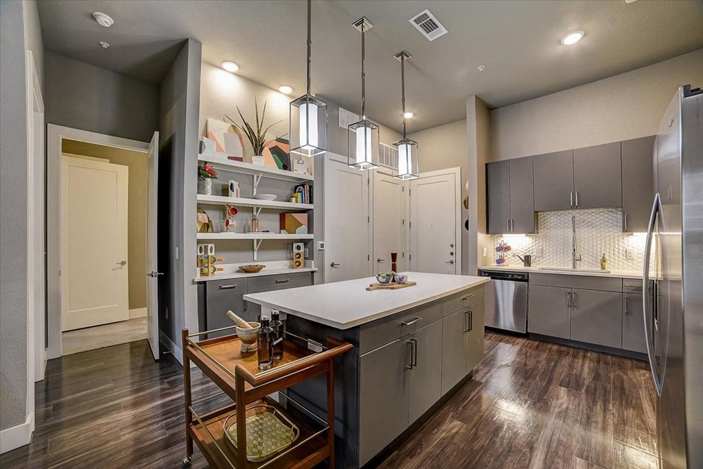 a kitchen with gray cabinets and a white counter top