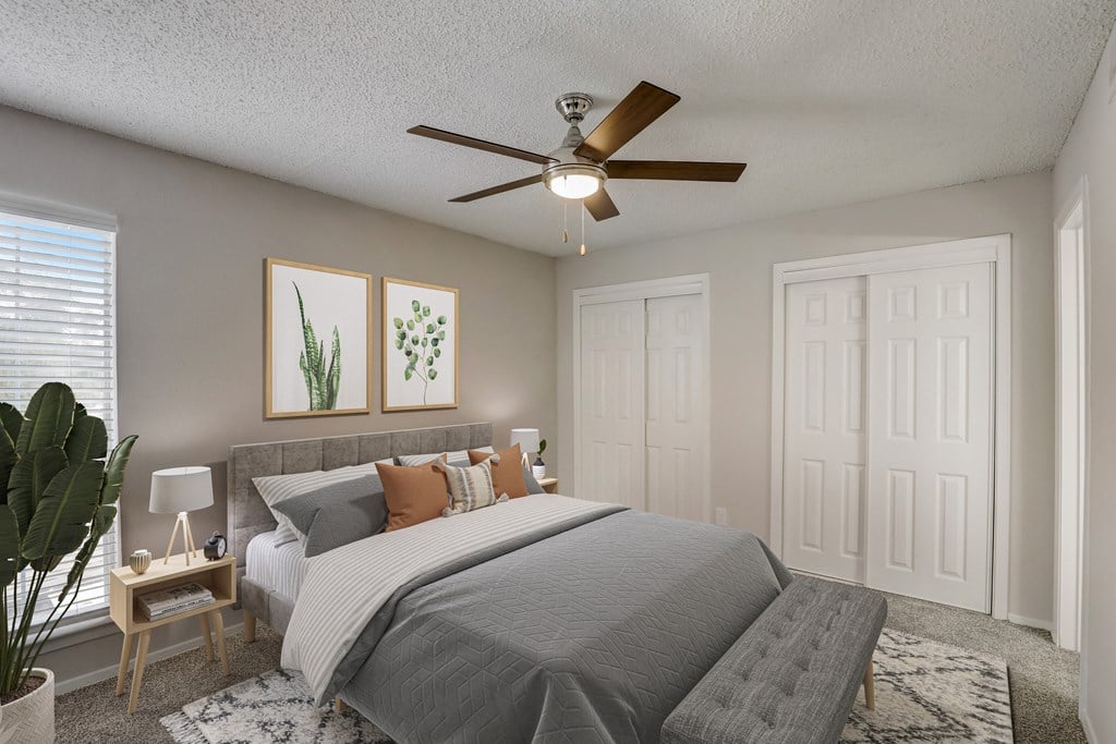 a bedroom with a ceiling fan and a bed