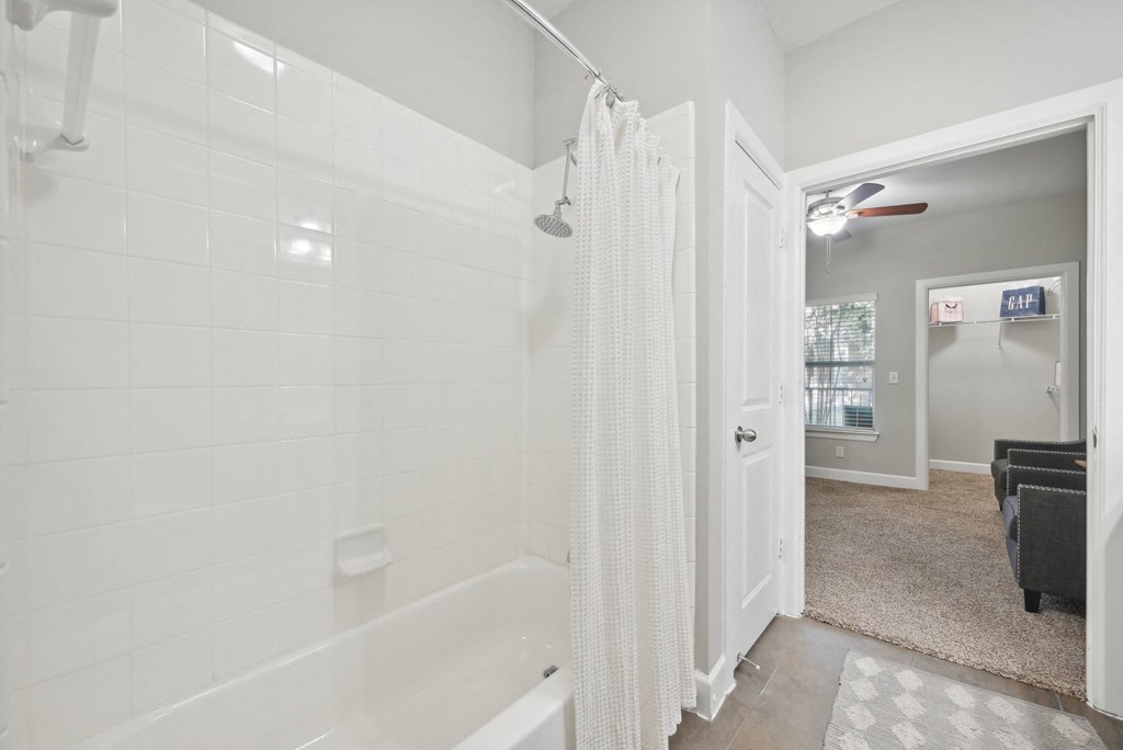 A white bathroom with a tub and a shower.