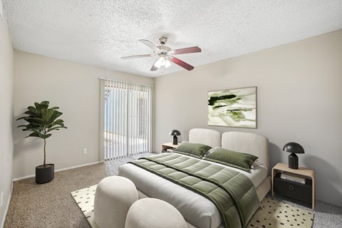 A bedroom with a bed, a plant, and a painting on the wall.