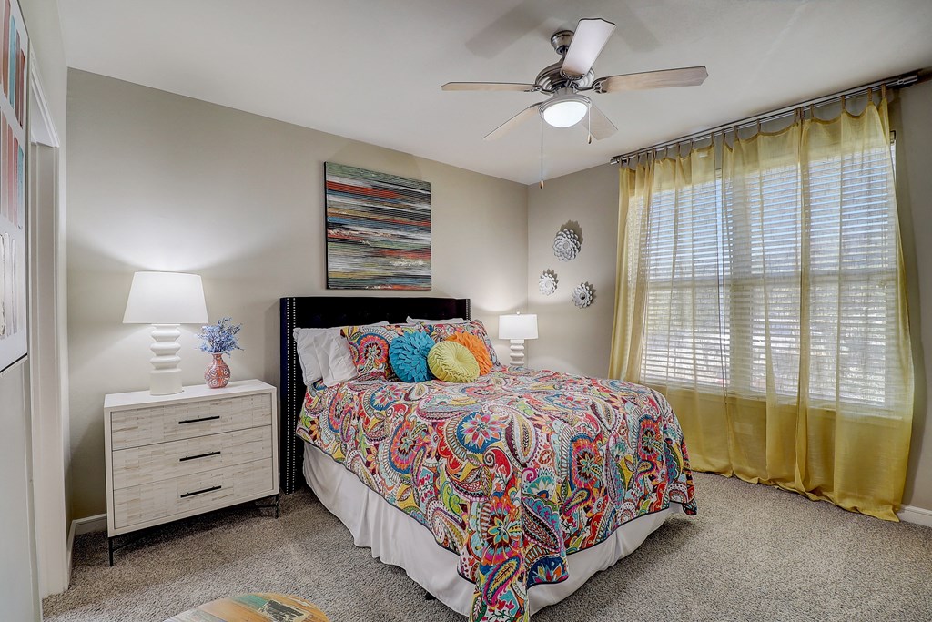 a bedroom with a bed and a ceiling fan