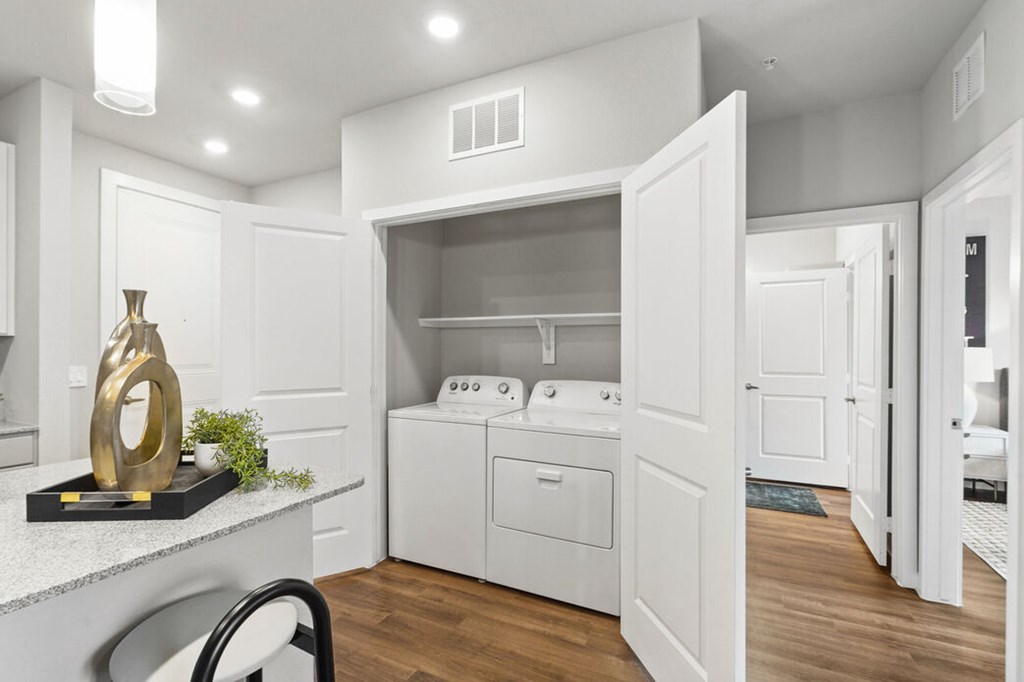 A modern laundry room with a washer and dryer built into the cabinetry.