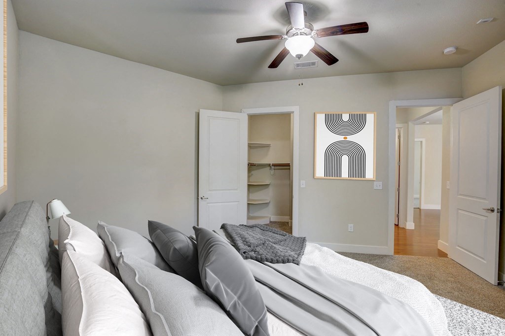 an empty bedroom with a bed and a ceiling fan
