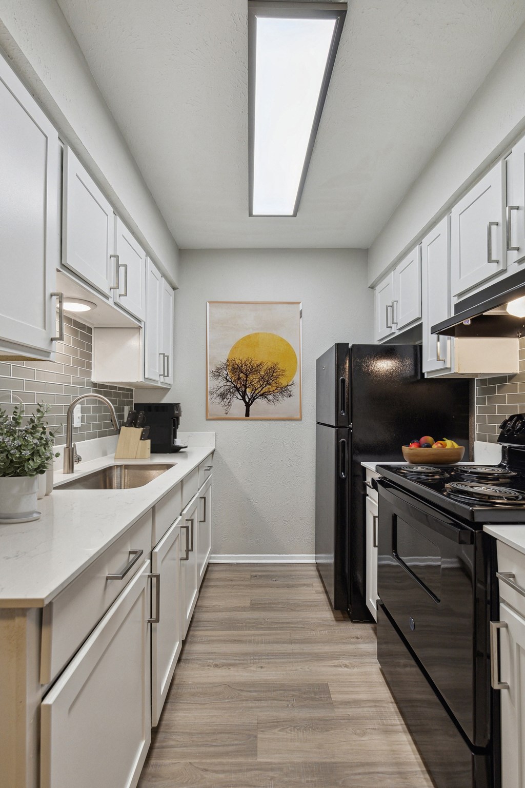 a kitchen with white cabinets and black appliances