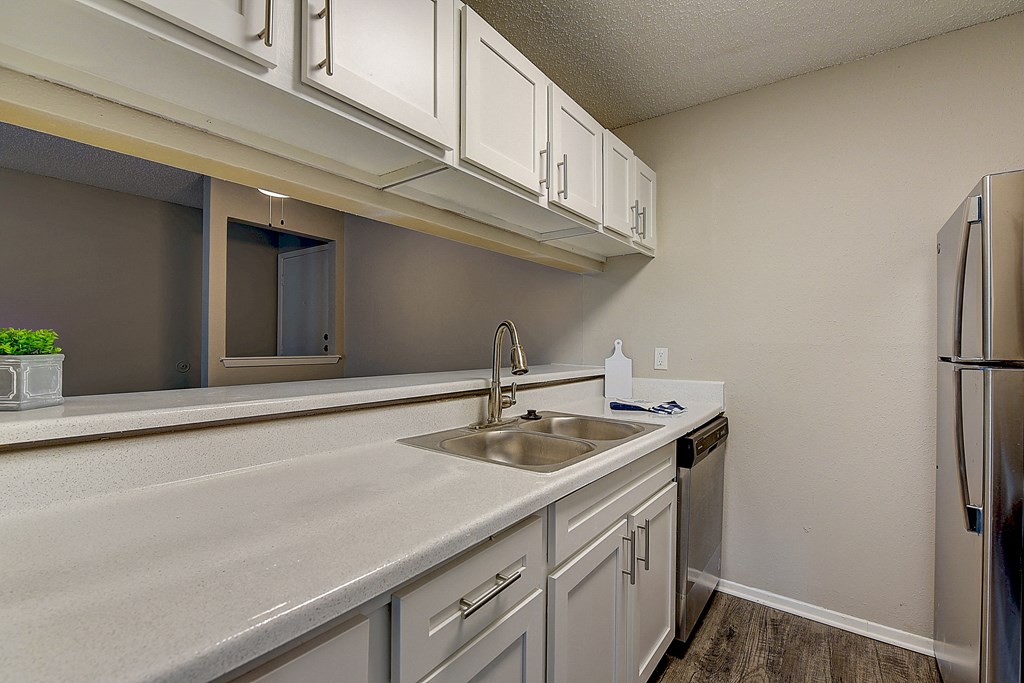 an empty kitchen with white cabinets and a sink