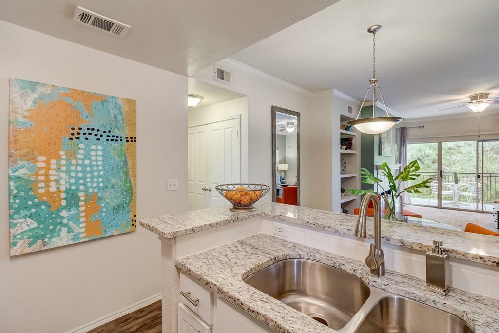 an open kitchen with a stainless steel sink and counter top