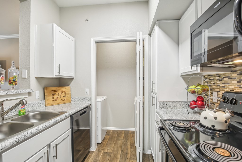 A kitchen with a black stove top oven and a white fridge.