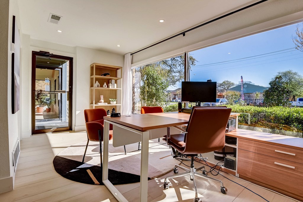 a home office with a large window and a table with chairs