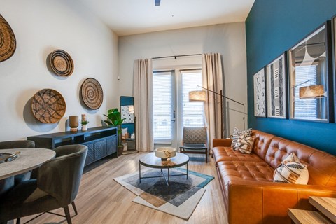 a living room with a blue accent wall and a brown couch