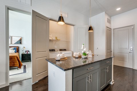 a kitchen with gray cabinets and a granite counter top