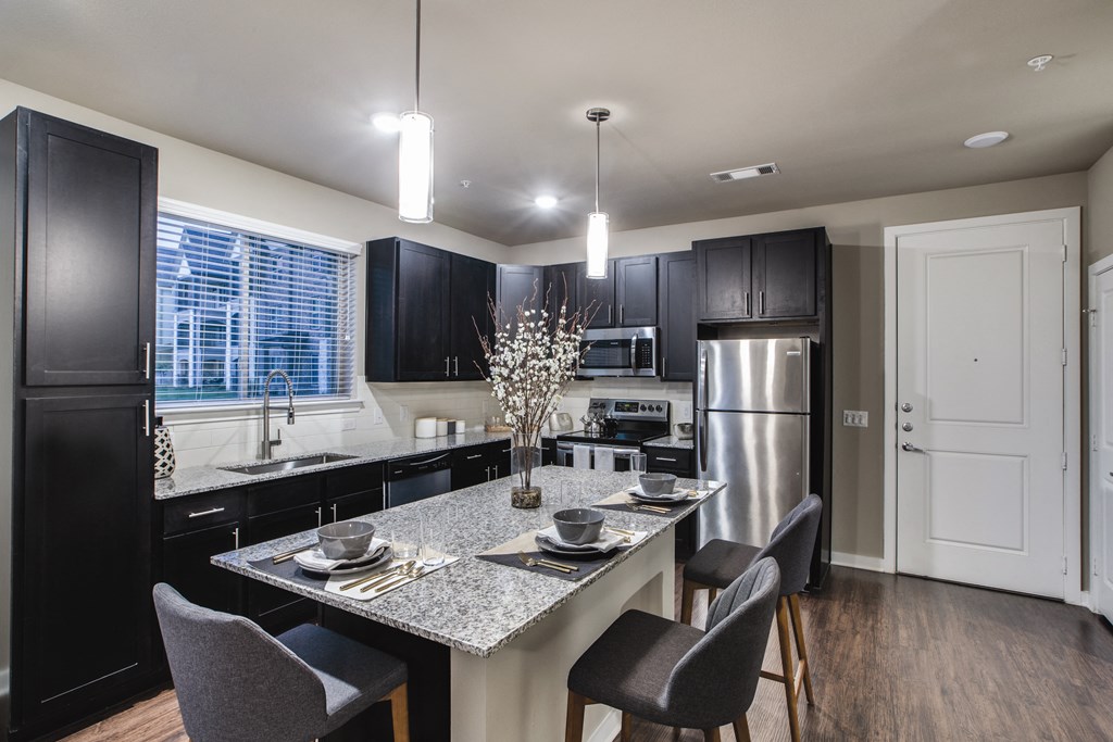 a kitchen with a large island with a granite countertop