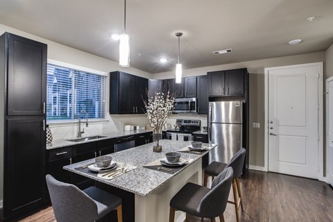 a kitchen with black cabinets and a granite counter top