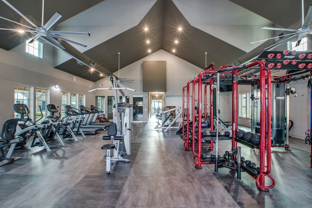 a spacious fitness center with cardio machines and weights
