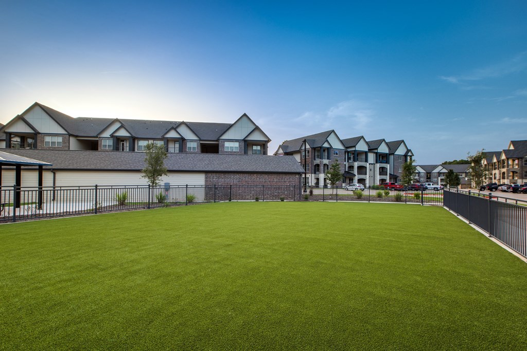 a large green lawn in front of a row of houses