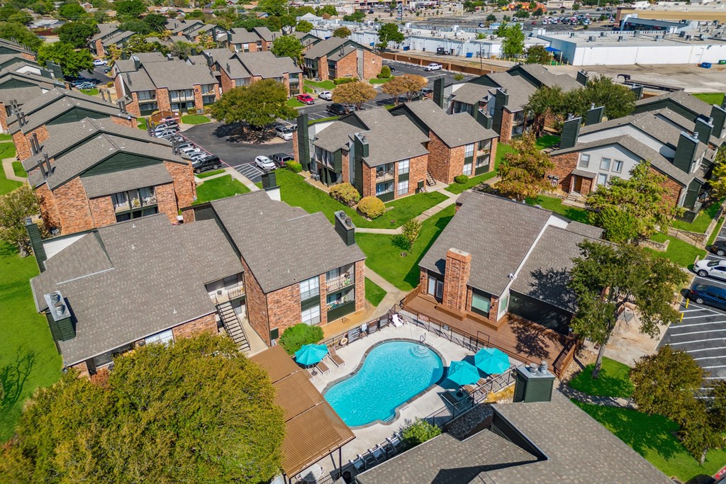 an aerial view of a neighborhood of houses with a swimming pool