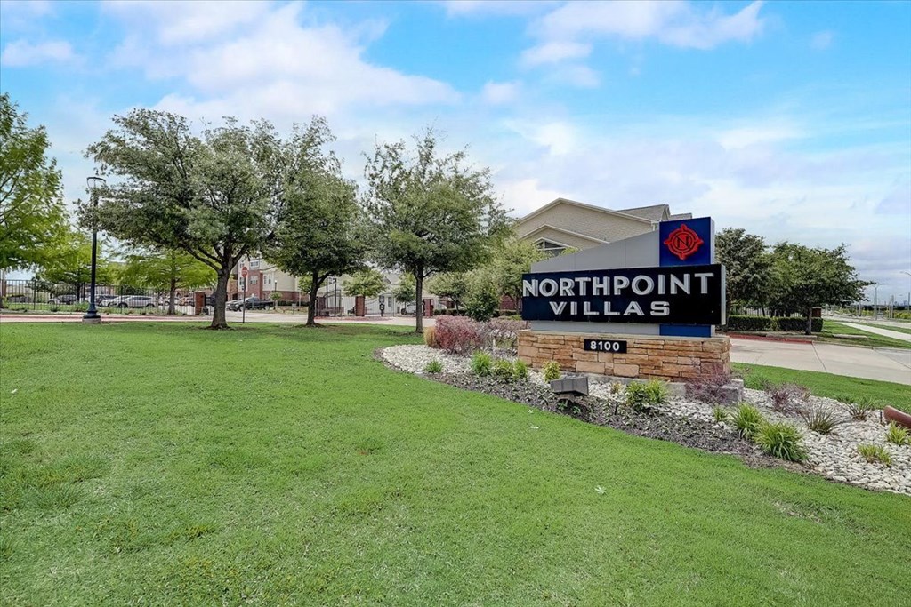 a sign for northpoint village with trees in the background