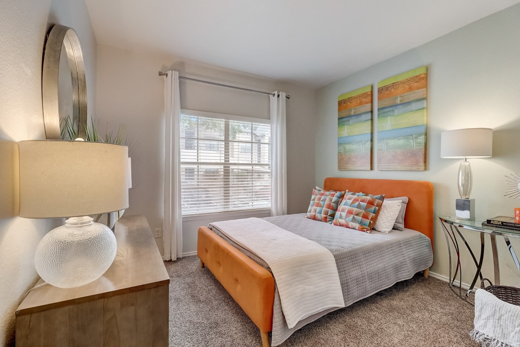 a bedroom with a bed and a desk and a window