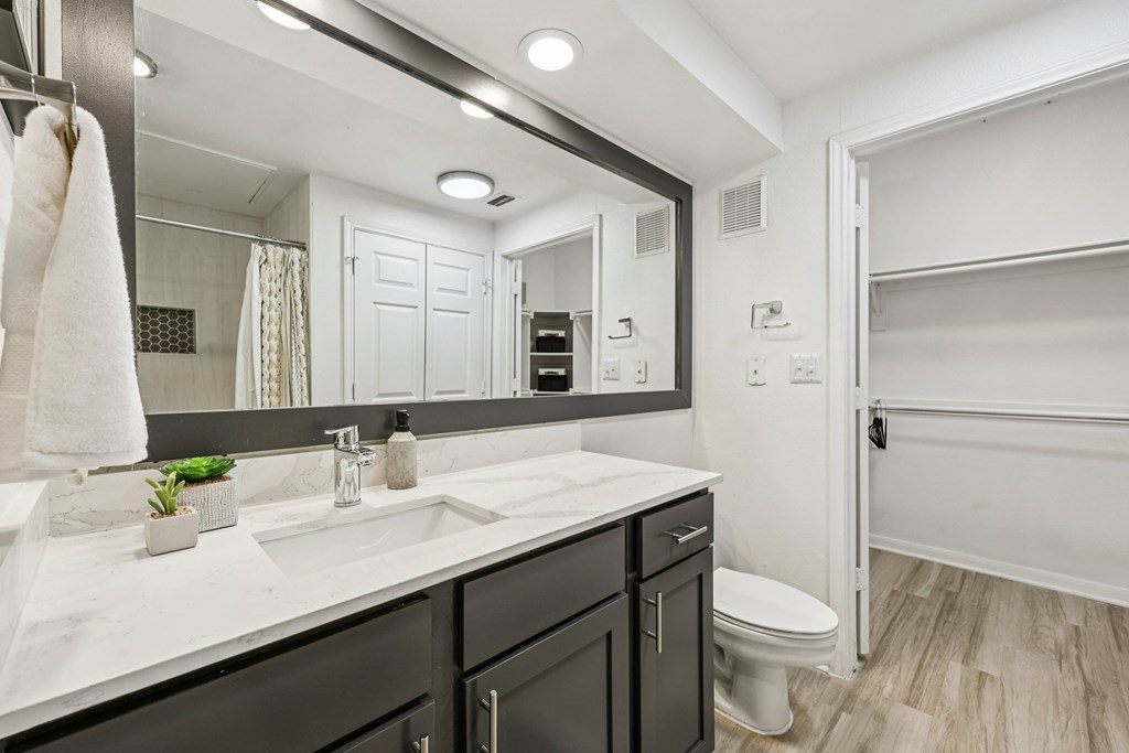 A bathroom with a white towel hanging on the door.
