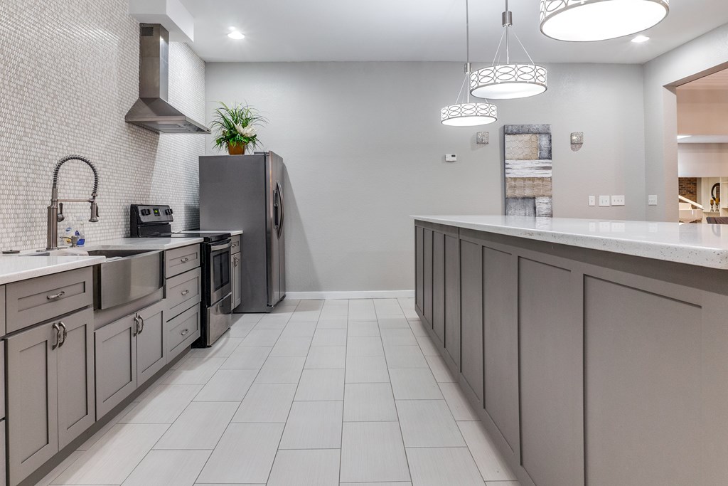 A modern kitchen with a grey color scheme and a large island.