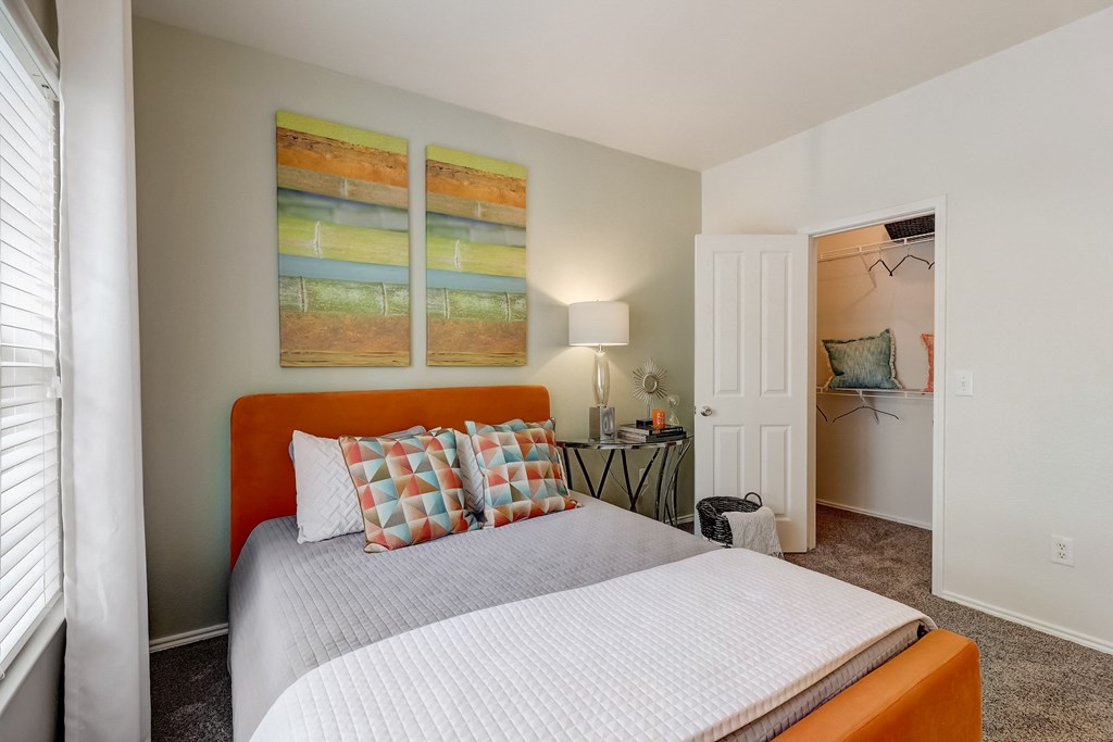 a bedroom with a bed and two paintings on the wall