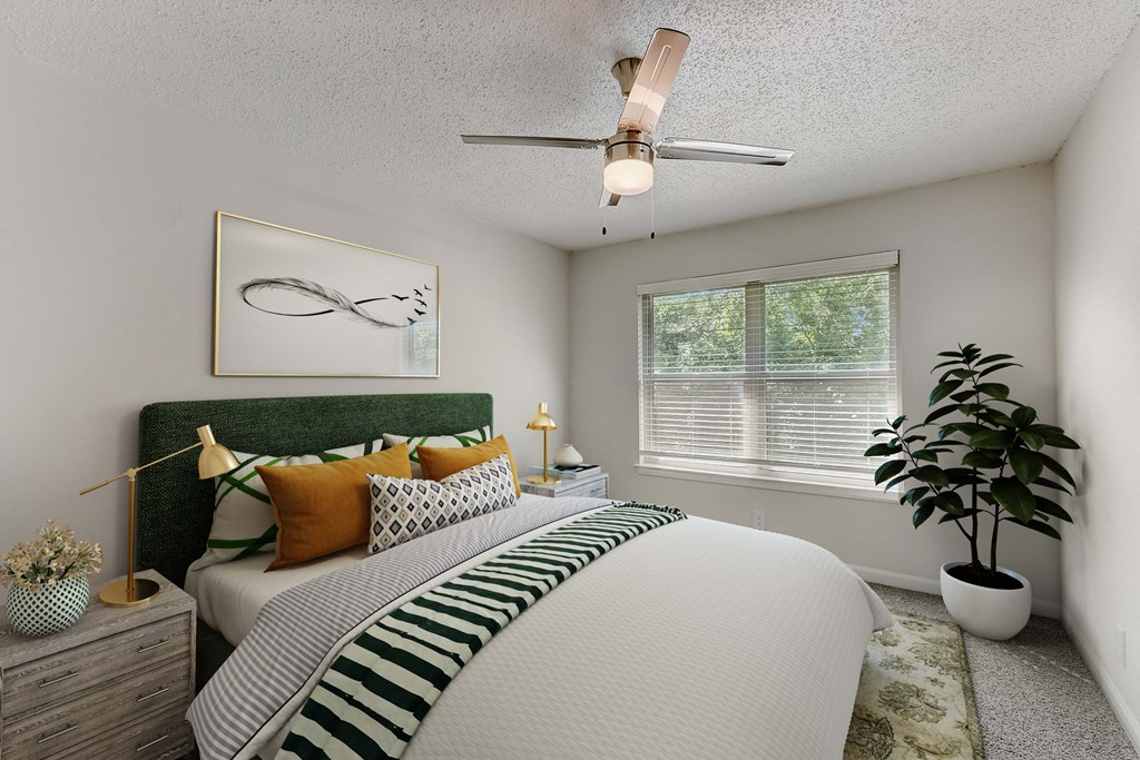 a bedroom with a large bed and a ceiling fan